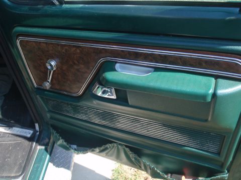 1978 Ford Bronco - The interior door panel of a 1978 Ford Bronco shows woodgrain trim and chrome accents.