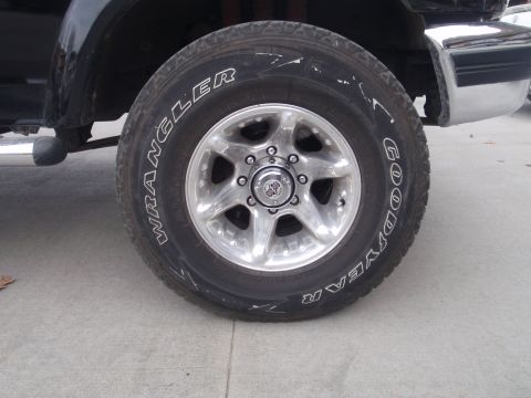 1994 Ford Bronco - Vehicle's front wheel and tire detail, with part of the chrome bumper visible.