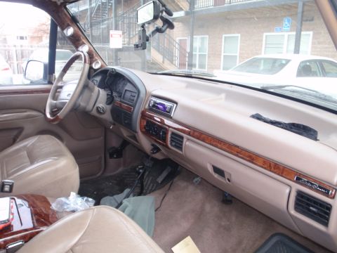 1994 Ford Bronco - The interior of a 1992 Ford Bronco shows tan leather seats, wood grain accents, and additional gauges on the A-pillar.