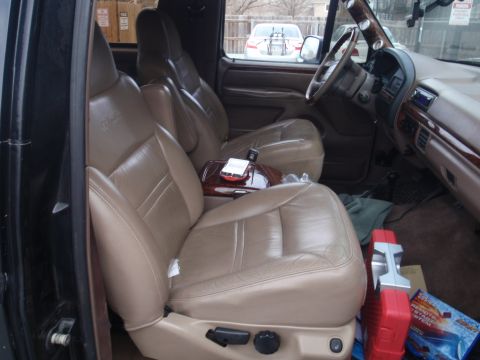 1994 Ford Bronco - The interior of a 1994 Ford Bronco features tan leather seats and wood trim accents.