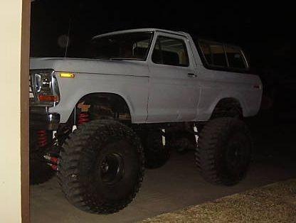 1978 Ford Bronco - A white 1978 Ford Bronco is heavily modified with a lifted suspension and large off-road tires.