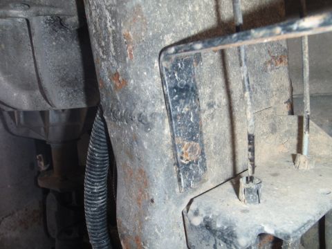 1994 Ford Bronco - Underbody view shows a metal bracket with rust and a black wire conduit.