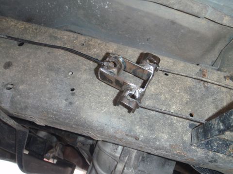 1994 Ford Bronco - Underside view of a custom-made bracket attached to the vehicle's frame, securing a brake cable.