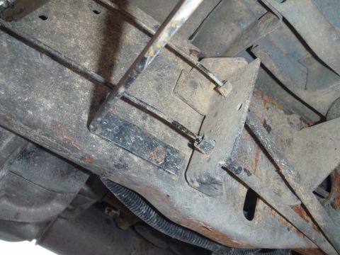 1994 Ford Bronco - Close-up view of the rusty undercarriage of a vehicle, showing structural components and wiring.