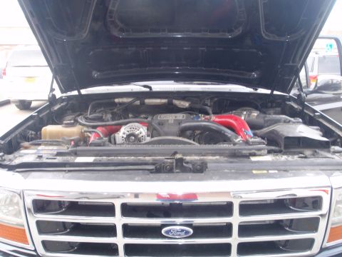 1994 Ford Bronco - The engine bay of a Ford truck, a prominent grille with the Ford logo and a watermark for Supermotors.net.