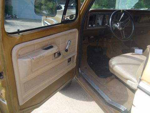 1978 Ford Bronco - Interior view of a 1978 Ford Bronco, highlighting the tan door panel and dashboard.