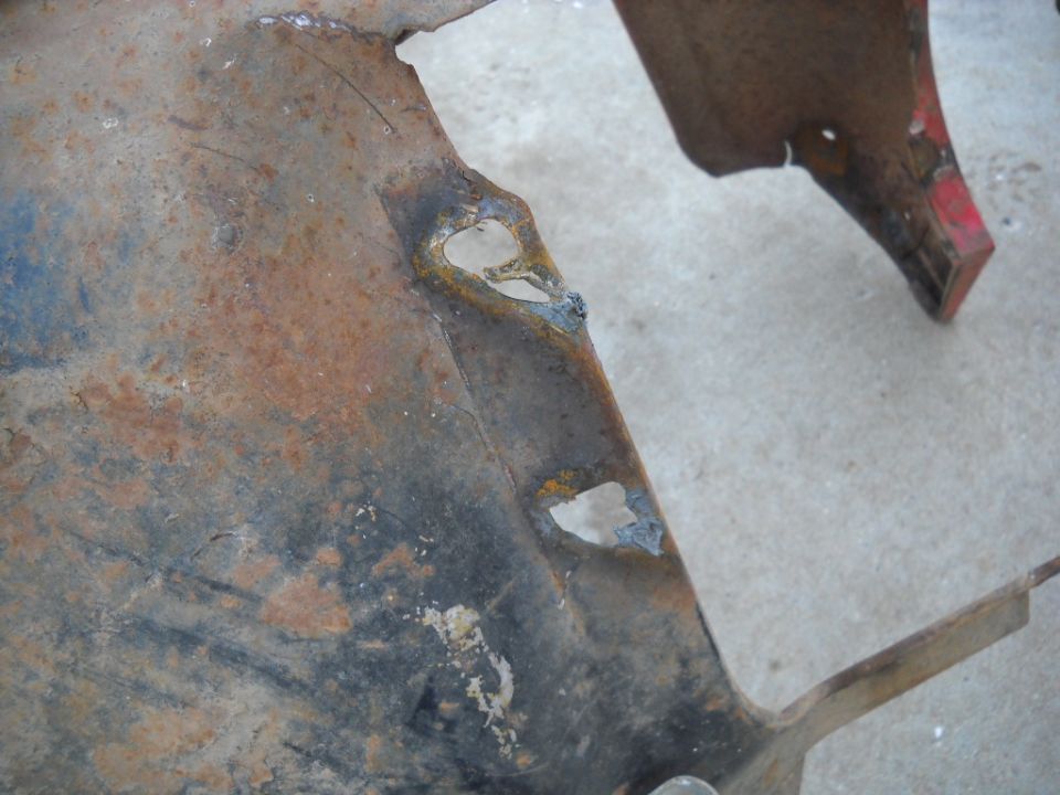Close-up of rusted sheet metal with welded patches