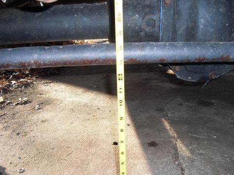 1986 Ford Bronco - A measuring tape is used to gauge the clearance of a vehicle's undercarriage components.