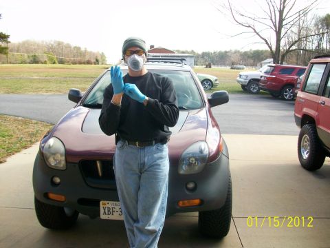 2000 Isuzu Vehicross - A person prepares to work on a 2000 Isuzu Vehicross, with other vehicles visible in the background.