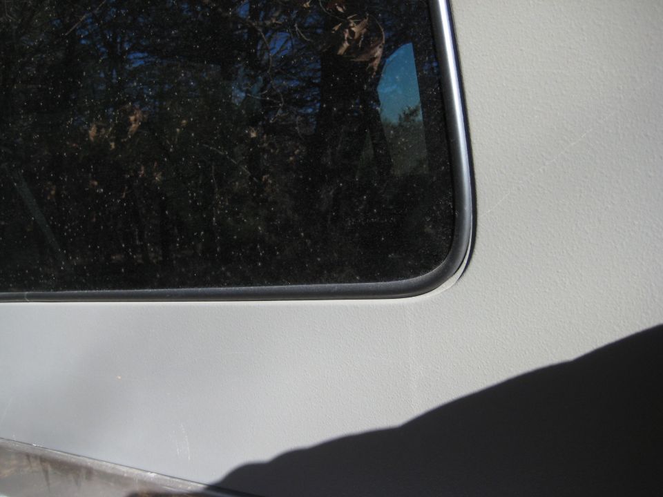 Gray vehicle side panel with a chrome-trimmed dark window; Supermotors.net watermark visible