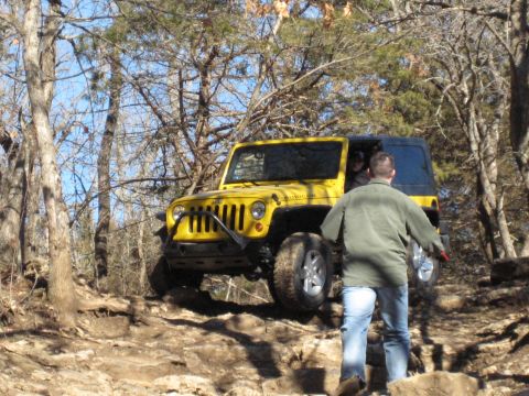 2005 Jeep Wrangler - Yellow Jeep Wrangler navigating a challenging off-road path.
