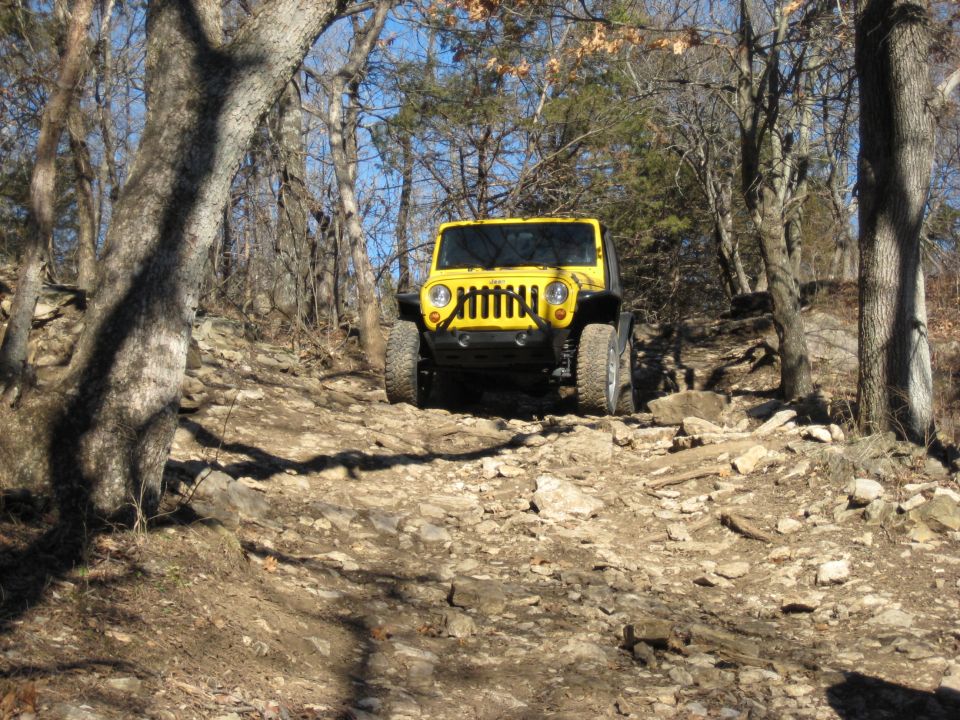 Yellow 2005 Jeep Wrangler front view on rocky trail