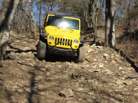 2005 Jeep Wrangler - Yellow Jeep Wrangler navigates a challenging rocky trail.