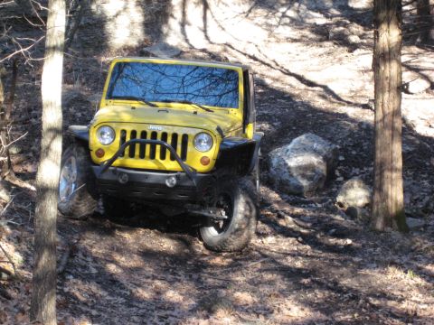 2005 Jeep Wrangler - Yellow Jeep Wrangler navigating an off-road trail.