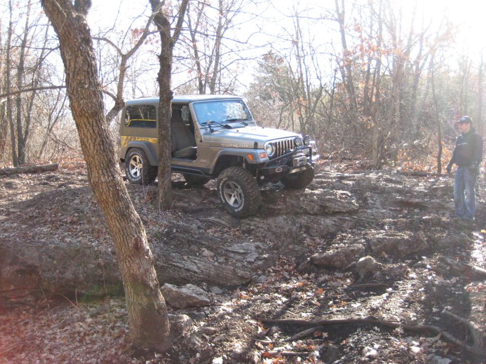 2005 Jeep Wrangler parked on a rocky hill in a wooded area