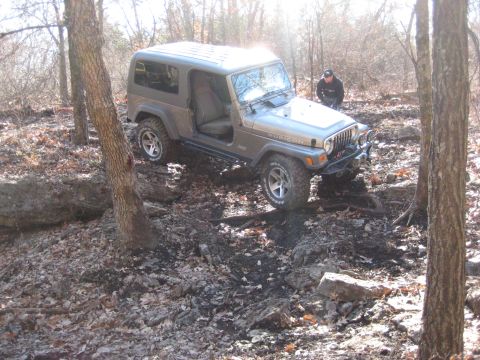 2005 Jeep Wrangler - This 2005 Jeep Wrangler Rubicon navigates a challenging off-road course with a person standing nearby.