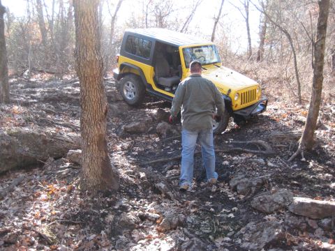 2005 Jeep Wrangler - A yellow 2005 Jeep Wrangler navigates a challenging, rocky off-road path.