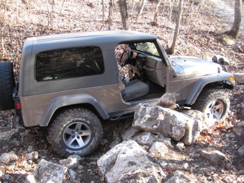 2005 Jeep Wrangler - A Jeep Wrangler navigates a rocky trail, demonstrating its off-road capability.