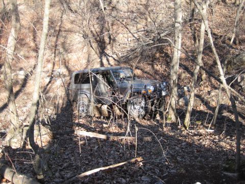 2005 Jeep Wrangler - Jeep Wrangler navigating a rough, wooded terrain.