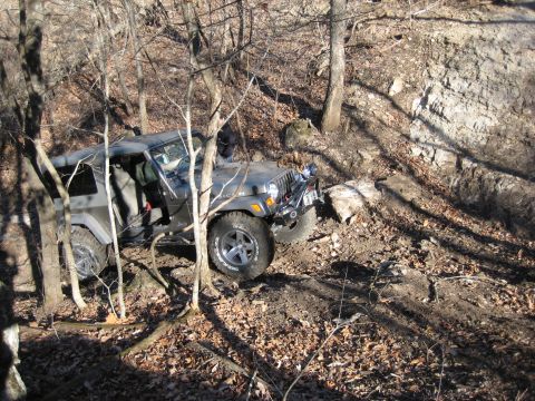 2005 Jeep Wrangler - Jeep Wrangler tackling a challenging off-road course in a wooded area.