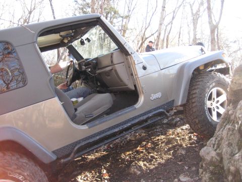 2005 Jeep Wrangler - A silver Jeep Wrangler navigates a rocky trail with its doors removed.