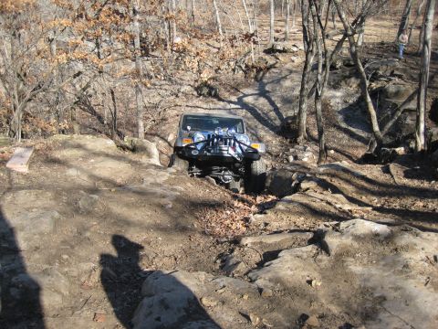 2005 Jeep Wrangler - A silver 2005 Jeep Wrangler tackles a challenging rocky terrain on an off-road trail.