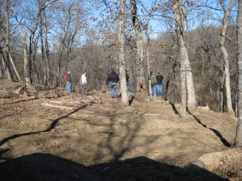2005 Jeep Wrangler - A group of people stand in a wooded area on a sunny day, with a dirt path in the foreground.