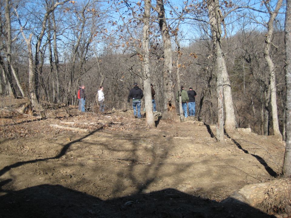 Wooded area with people standing on a dirt path