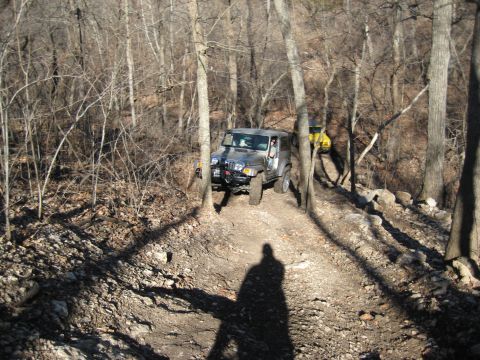 2005 Jeep Wrangler - Two Jeeps navigating a rocky, wooded trail in the winter.