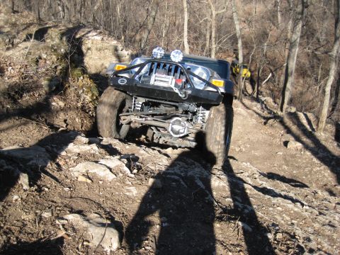 2005 Jeep Wrangler - Modified 2005 Jeep Wrangler tackles a challenging rocky trail, with another vehicle in the distance.
