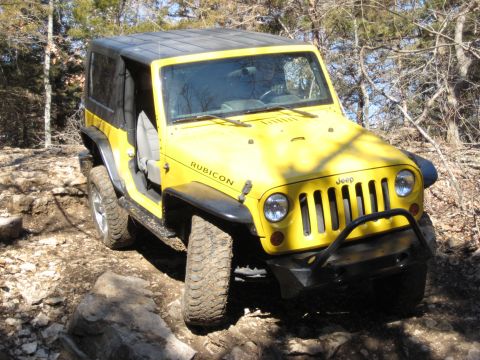 2005 Jeep Wrangler - This yellow Jeep Wrangler Rubicon is navigating a rocky off-road trail.