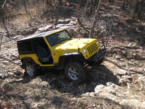 2005 Jeep Wrangler - This yellow 2005 Jeep Wrangler Rubicon is shown tackling a challenging rocky terrain on an off-road trail.
