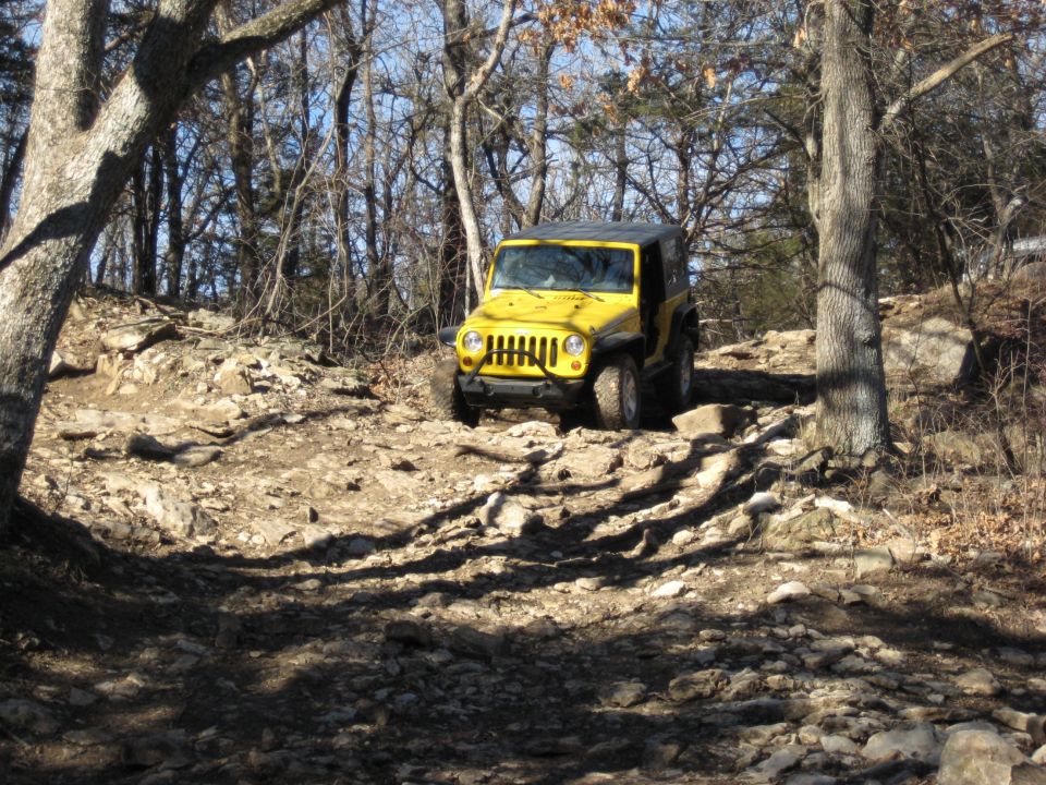 Yellow 2005 Jeep Wrangler navigating a rocky off-road trail
