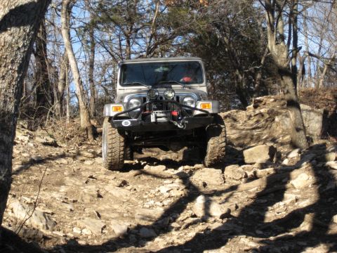 2005 Jeep Wrangler - Silver 2005 Jeep Wrangler navigates a challenging rocky trail in a wooded area.