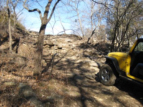 2005 Jeep Wrangler - A yellow Jeep Wrangler navigates a rocky trail, demonstrating its off-road capabilities.