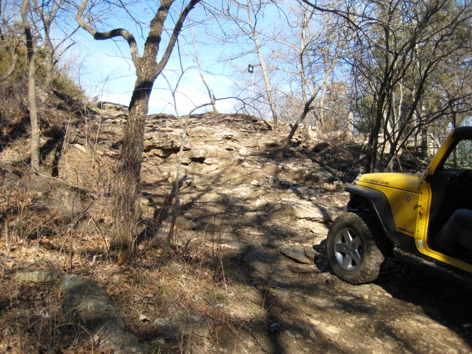 Yellow Jeep Wrangler on rocky terrain, front-right quarter view