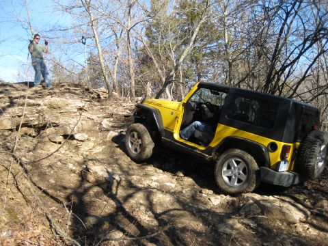 2005 Jeep Wrangler - Yellow 2005 Jeep Wrangler Rubicon navigating a rocky off-road trail with a person observing.