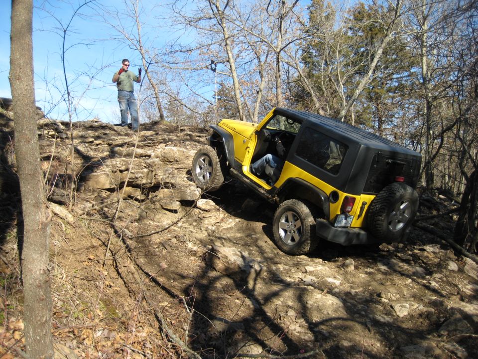 Yellow 2005 Jeep Wrangler navigating a rocky incline