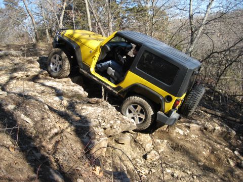 2005 Jeep Wrangler - This yellow 2005 Jeep Wrangler navigates a challenging rocky terrain during an off-road excursion.