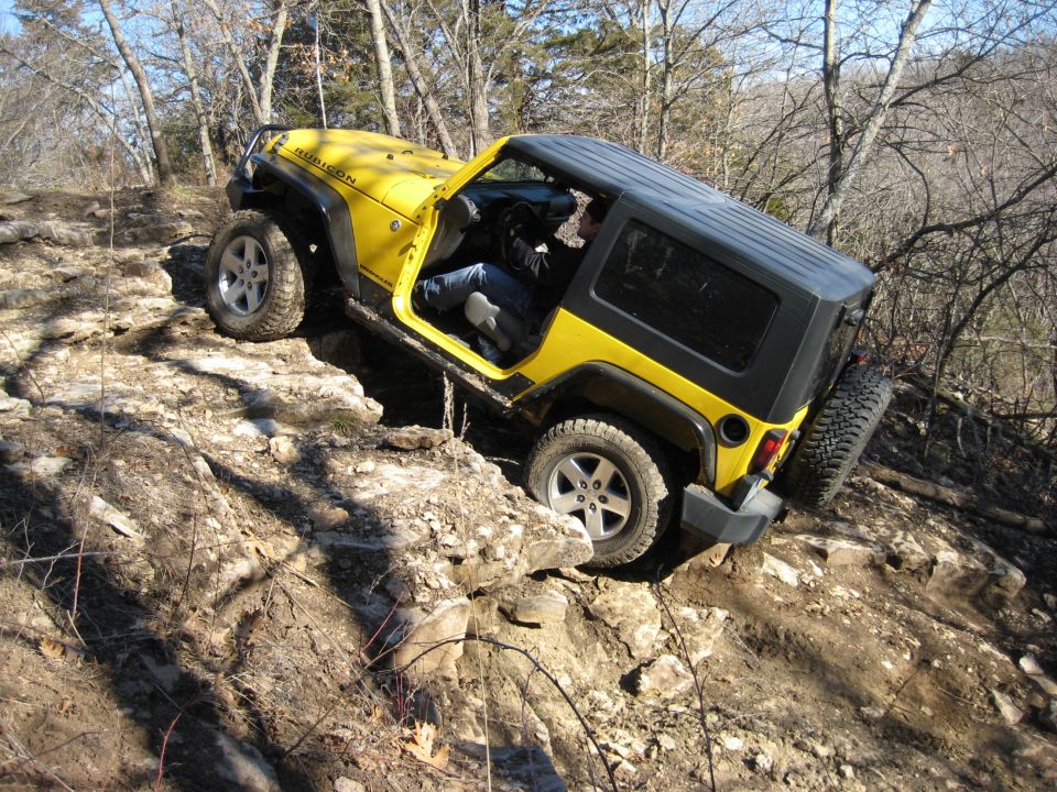 Yellow 2005 Jeep Wrangler off-roading on a rocky trail