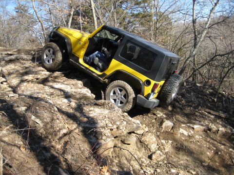 2005 Jeep Wrangler - Yellow Jeep Wrangler Rubicon navigating a steep, rocky trail with its doors off.