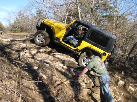 2005 Jeep Wrangler - A yellow 2005 Jeep Wrangler Rubicon navigates a rocky trail with two people inside.