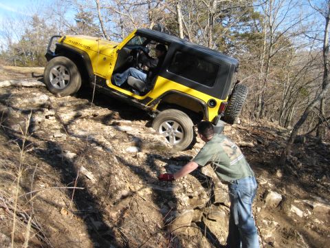 2005 Jeep Wrangler - A yellow 2005 Jeep Wrangler Rubicon is shown off-roading on a challenging rocky incline.