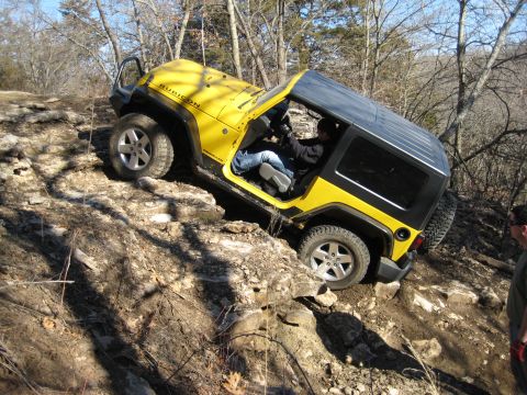 2005 Jeep Wrangler - Yellow Jeep Wrangler Rubicon navigating a steep, rocky trail.