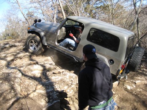 2005 Jeep Wrangler - A Jeep Wrangler navigates a challenging rocky trail, with a spotter guiding the driver.