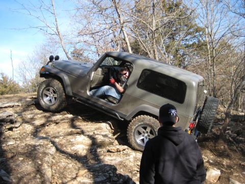 2005 Jeep Wrangler - A gray 2005 Jeep Wrangler Rubicon tackles a challenging rocky trail with a driver and observer present.