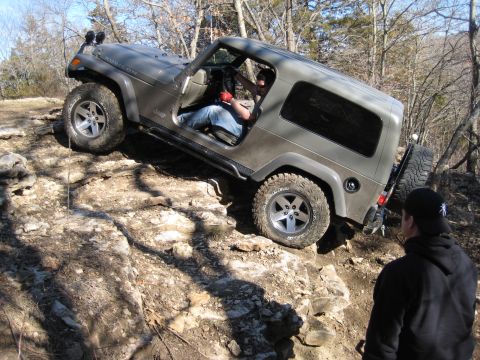 2005 Jeep Wrangler - Driver maneuvers a 2005 Jeep Wrangler Rubicon over a challenging rocky incline.