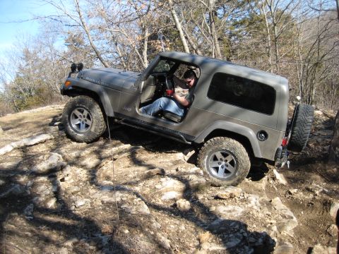 2005 Jeep Wrangler - A Jeep Wrangler navigates a rocky off-road trail, its capability on challenging terrain.