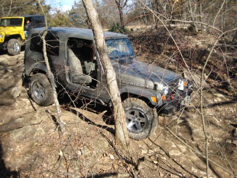 2005 Jeep Wrangler - A gray Jeep Wrangler Rubicon navigates a rocky trail, with another Jeep visible in the background.