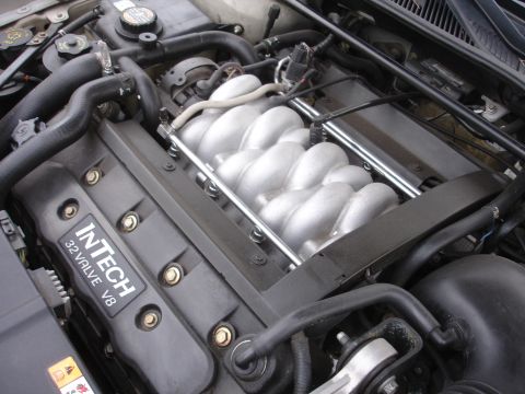 2000 Lincoln Continental - Close-up of a V8 engine with prominent intake manifold and "InTech 32 Valve V8" badging.